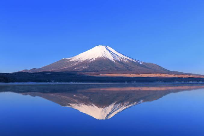 湖面に逆さ富士が映る、雪化粧した富士山